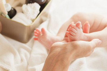 Fototapeta na wymiar Hands of woman holds baby feet