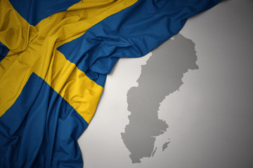 waving colorful national flag and map of sweden.