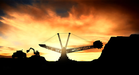Coal mine with big excavator machine at sunset