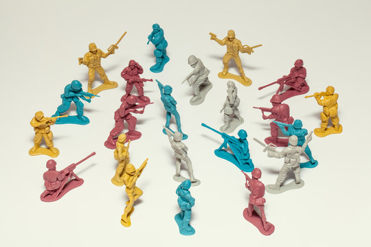 macro group of plastic toy soldiers making war on white background