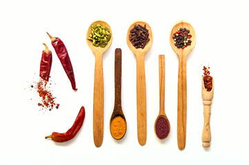 Wooden spoons with spices isolated on white background. The concept of vegetarian food,  healthy diet, choice of clean food, copy space, closeup.