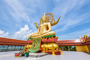 Large gold buddha statue in a sitting position under the blue sky at Big Buddha Temple is a famous tourist destination of Koh Samui island, Surat Thani province, Thailand