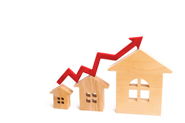 Wooden houses stand in a row from small to large with a red arrow up. concept of high demand for real estate. increase energy efficiency of housing. rise in house prices. property.