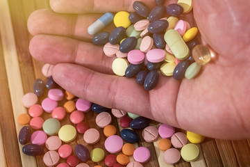 Macro photo of human hand with colorful pills