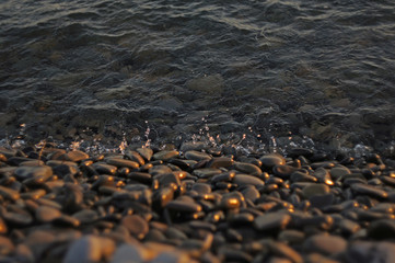 Drops of waves near the sea at sunset.