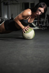 Fitness girl does push-ups on the ball