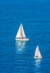 Two White Sailboats on Blue