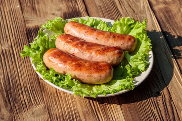 Grilled sausages on wooden table