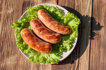 Grilled sausages on wooden table