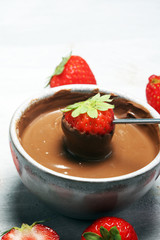 Fondue with Melting chocolate or melted chocolate and strawberry.