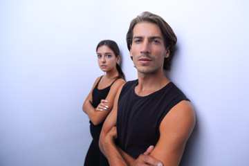 serious young couple standing near the wall