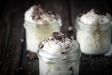 Ice cream with chocolate cookies in glass jars.