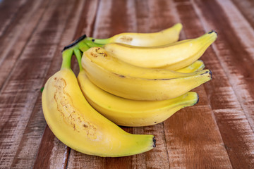 Colorful fresh bananas on wooden background