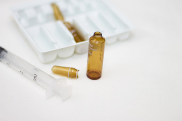 Empty medical ampoules infusion and used syringe after injection isolated on white background