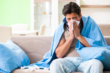 Sick young man suffering from flu at home - obrazy, fototapety, plakaty