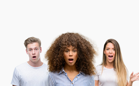 Group of young people over white background scared in shock with a surprise face, afraid and excited with fear expression