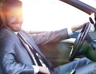 Handsome businessman in the drivers seat in his car