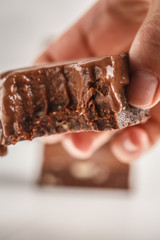 Stack of chocolate fudge bars on white background. Raw vegan dessrt.
