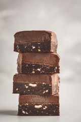 Stack of chocolate fudge bars on white background. Raw vegan dessrt.