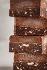 Stack of chocolate fudge bars on white background. Raw vegan dessrt.
