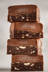 Stack of chocolate fudge bars on white background. Raw vegan dessrt.