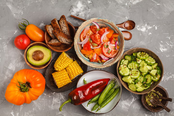 Fototapeta na wymiar Clean eating concept. Cucumber salad, tomato salad, flax bread, avocado, corn. Top view, food background.