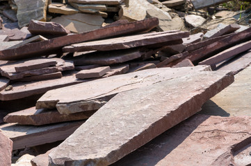 Stone sandstone (slate) is chopped on construction work. A stone of sandstone lies on a pile for building a house.