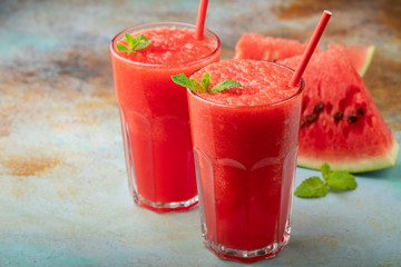 Watermelon slushie with lime, summer refreshing drink in tall glasses on a blue rusty background. with copy space