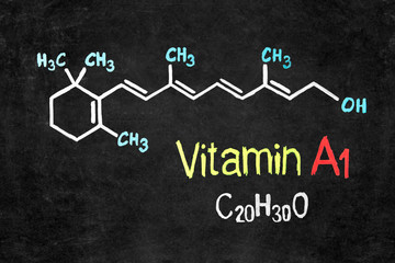 Handwritten chalk chemical formula of Vitamin A on school blackboard.