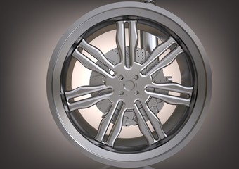 Obraz premium The silver wheel and the brake disc on a gray