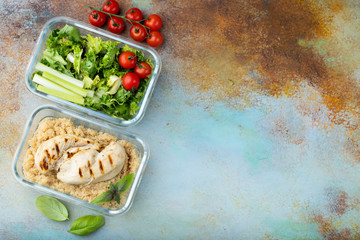 Healthy meal prep containers with quinoa, chicken breast and green salad overhead shot with copy space. Top view. Flat lay