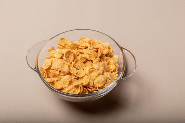 corn flakes in a glass plate on a gray background.