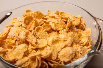 corn flakes in a glass plate on a gray background.