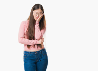 Young Chinese woman over isolated background wearing glasses thinking looking tired and bored with depression problems with crossed arms.