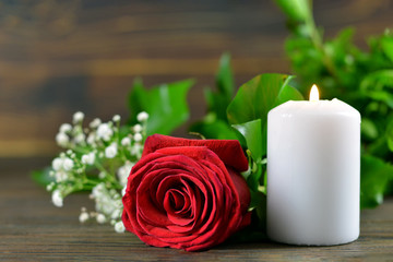 White burning candle and red rose