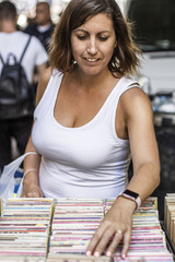 Woman searching an old book on a street market