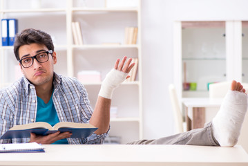 Young student man with hand injury preparing for the exams 