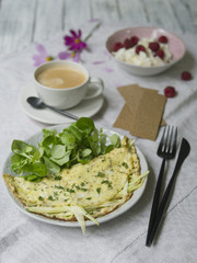 Omelet with zucchini and mushrooms. Cozy breakfast: omelette with zucchini,  cottage cheese with raspberries, bread and a cup of coffee. Healthy food. Close up, copy space