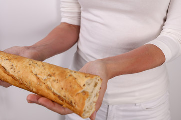 Woman suffering from Wheat and Gluten Allergy holding bread. Food allergy symptoms rush, itching, skin redness.