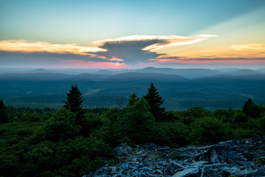 The sun sets behind a giant thunderstorm cloud in the Appalachian Mountains seen from Spruce Knob in West Virginia