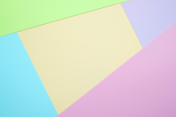Fashionable  pastel colored paper flat lay top view, geometric background texture, pink, purple, yellow, beige, green and blue.