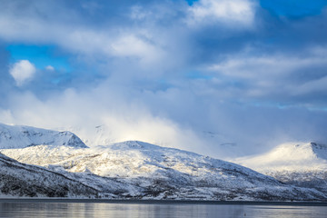 Fototapeta na wymiar View on snowy mountain peaks during a winter storm