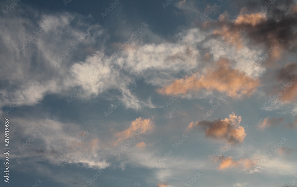 Wall mural Evening sky with white, pink and gray clouds.