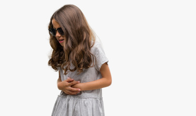 Brunette hispanic girl wearing sunglasses with hand on stomach because nausea, painful disease feeling unwell. Ache concept.