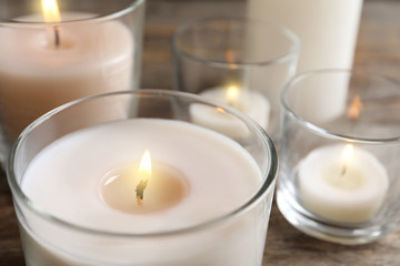 Burning wax candle in glass holder, closeup