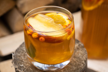 hot autumn drink cider from apples with lemon, cinnamon, sea buckthorn and anise stars