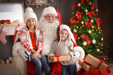 Little children and authentic Santa Claus indoors