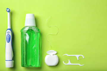 Flat lay composition with electric toothbrush and oral hygiene products on color background