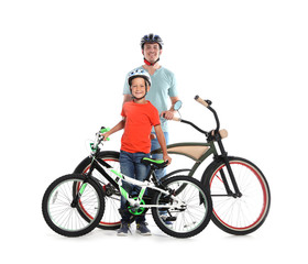 Obraz premium Portrait of father and his son with bicycles on white background