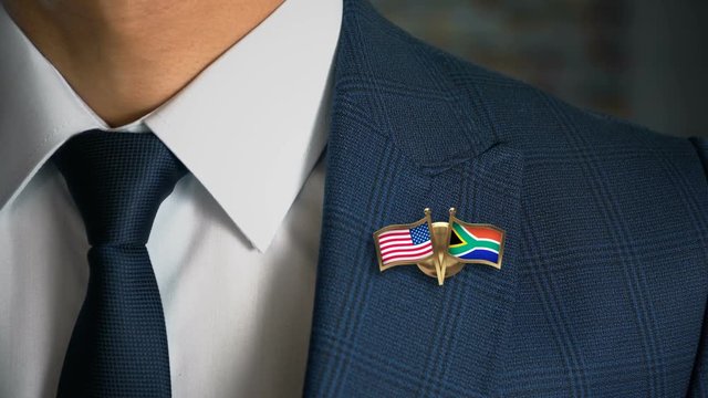 Businessman Walking Towards Camera With Friend Country Flags Pin United States of America -  South Africa